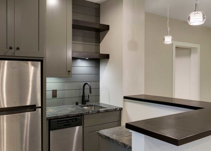 Black countertop and dark grey cabinets in modern kitchen
