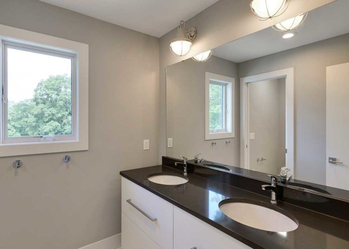 White bathroom with double vanity and black countertop