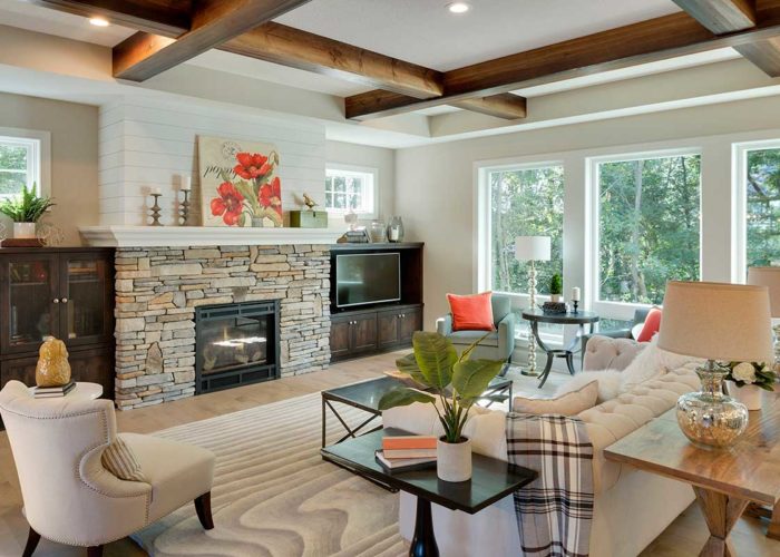 Cozy great room with stacked stone fire place and exposed beam ceiling