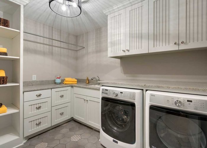Laundry room with grey tile floor and yellow accents