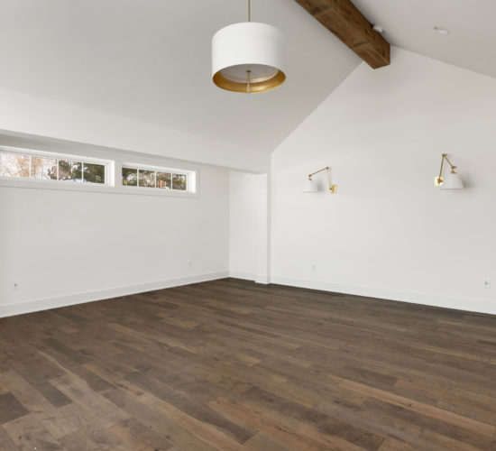 owners room with beamed ceiling and wall sconces