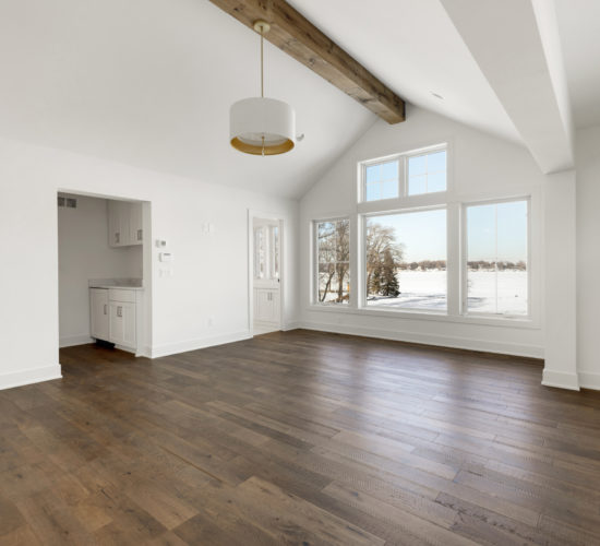 owners room with beamed ceiling, bar, and wall of windows