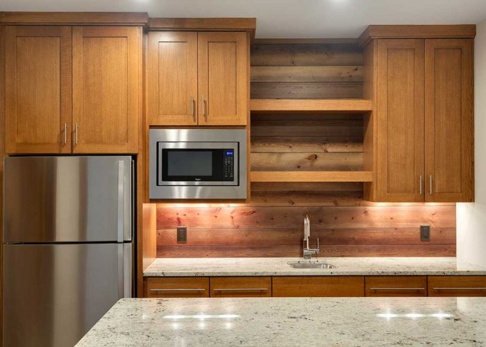 Warm wood cabinets in kitchen with wood back splash