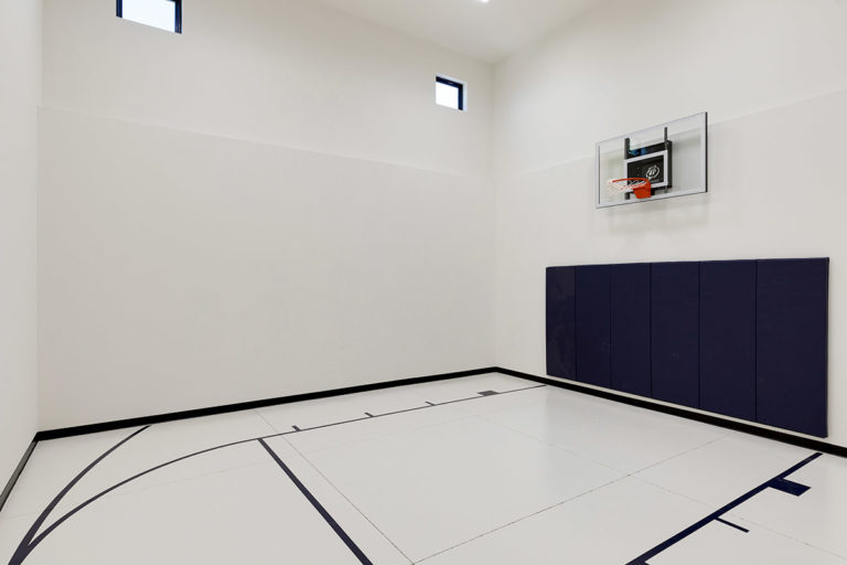 White white indoor sportcourt with basketball hoop