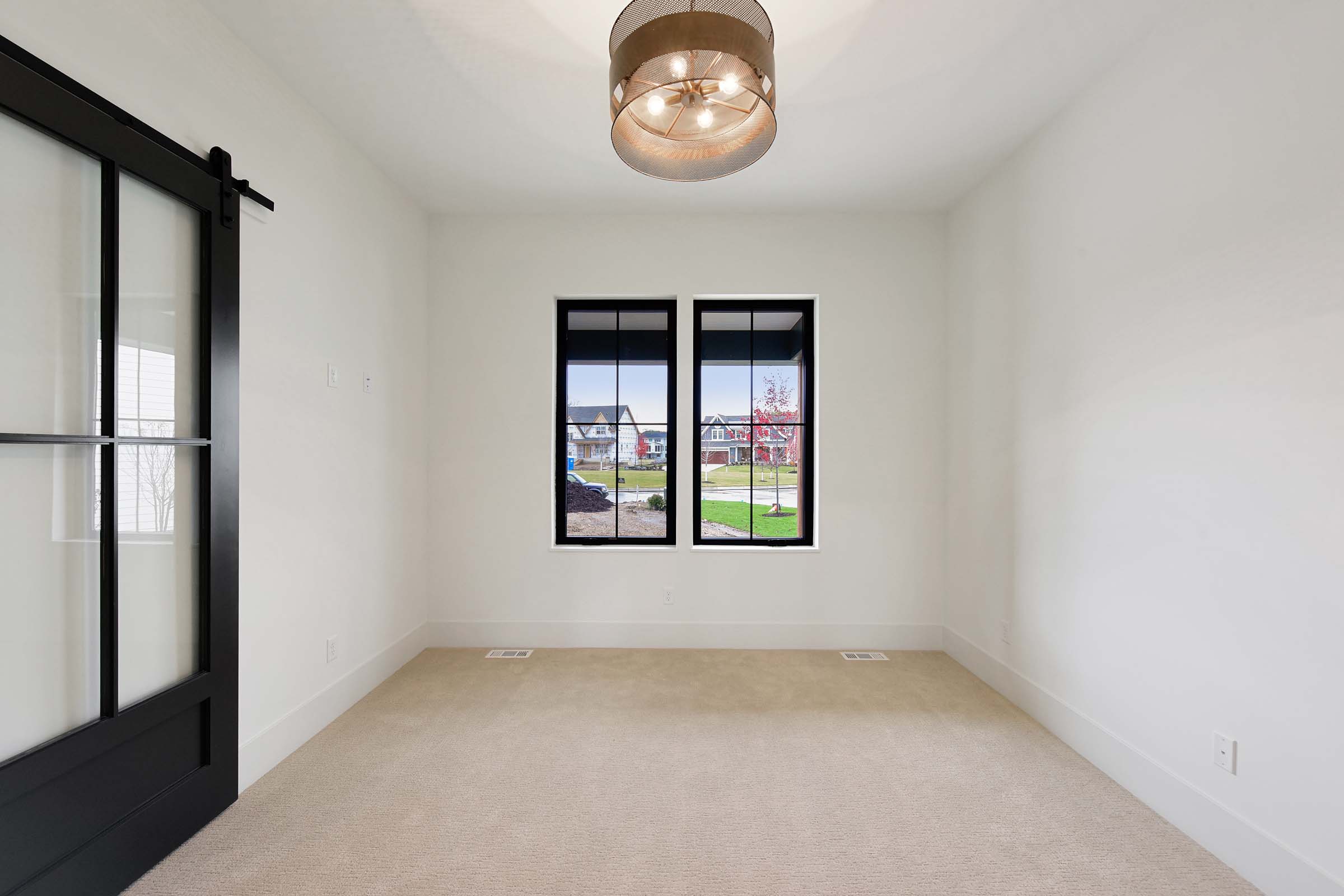 office with two windows and sliding barn door with windows