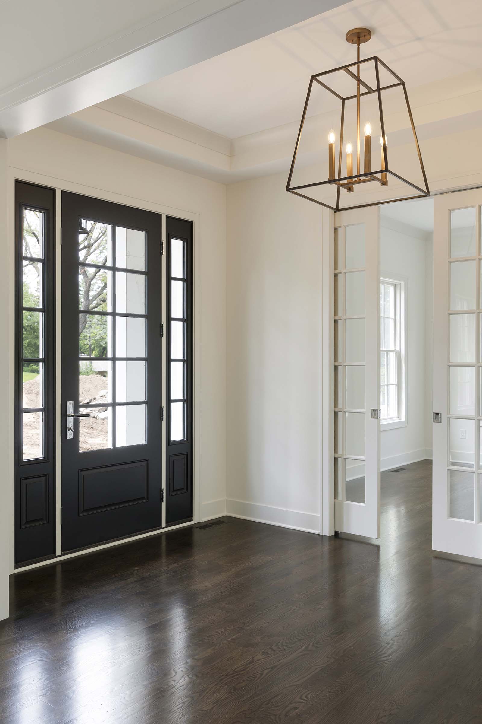 Colonial On The Creek Foyer Black Door and Designer Lighting