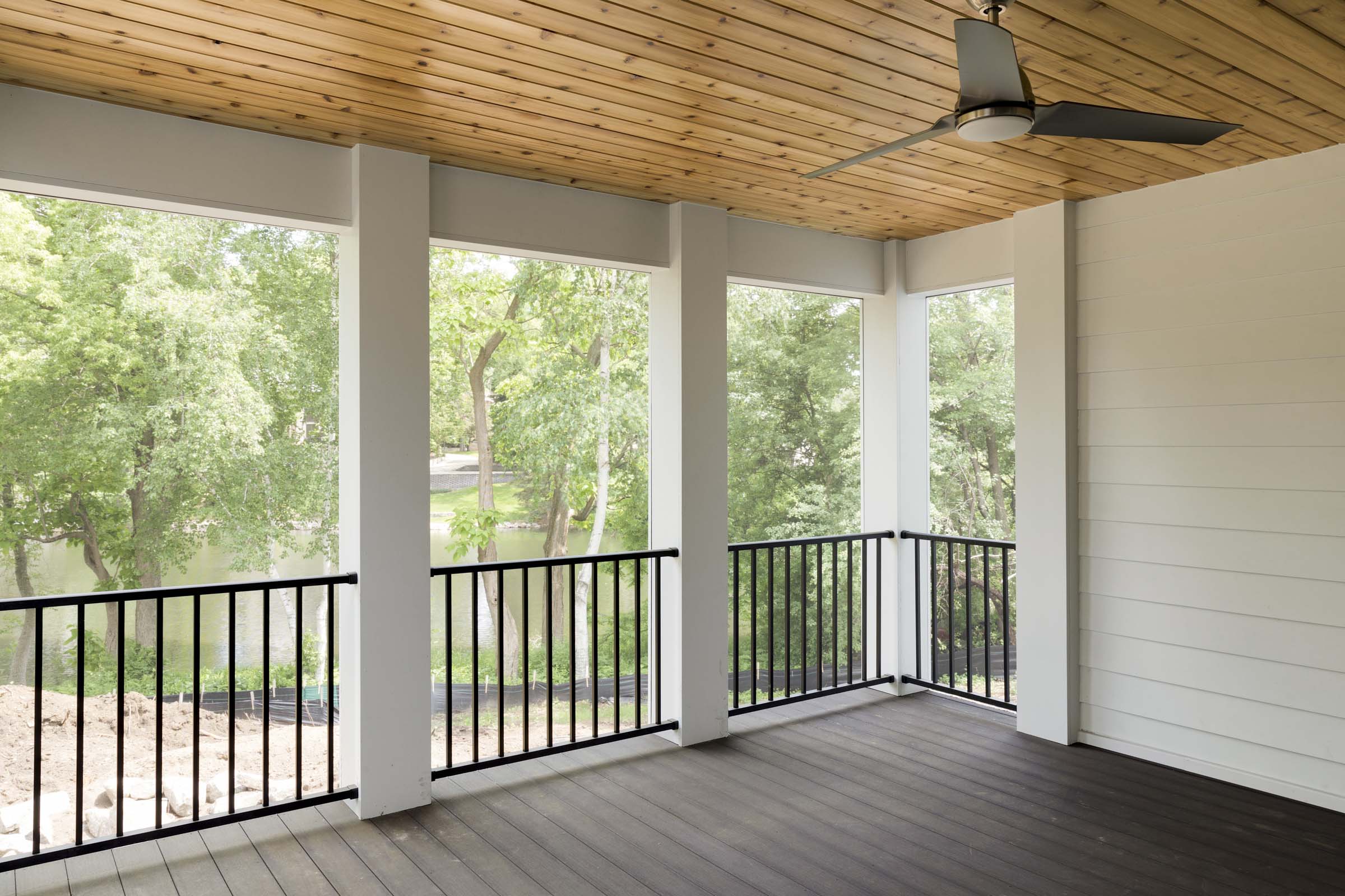 Colonial On The Creek Screen Porch with black railing and cedar roof