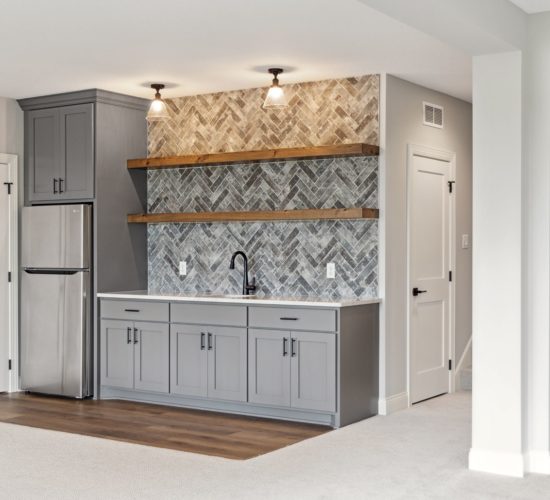 Bar with gray cabinets, wood floating shelves, and tiled backsplash